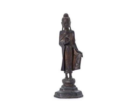 A SOUTH-EAST ASIAN BRONZE BUDDHA STATUE
Probably Thai, modelled standing on a lotus, left hand holding robe and an object (pr