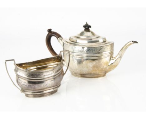 A Georgian style white metal teapot and similar sugar basin, the oval teapot with wooden handle and finial having engraved fl