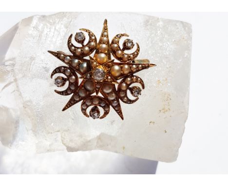 An Edwardian seed pearl and diamond brooch, of star design with sickle moons centred with old cut diamond and half cut pearls