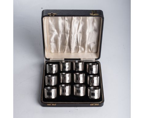 J Gloster, Birmingham, 1946, with engine-turned decoration enclosing a vacant panel, 420g;  two further napkin rings, WH Spar
