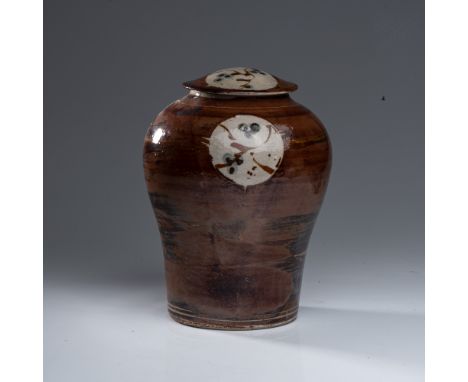 The narrow base widening to a broad shoulder with a circular cartouche with abstract motif, 31cm high