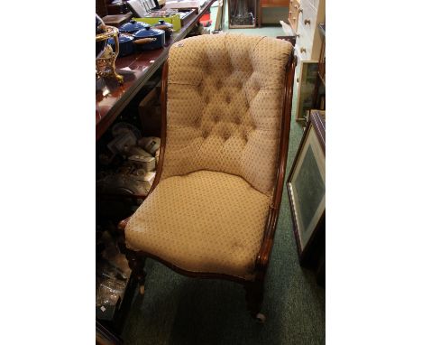 Victorian button back chair on mahogany frame over turned legs and caster feet 