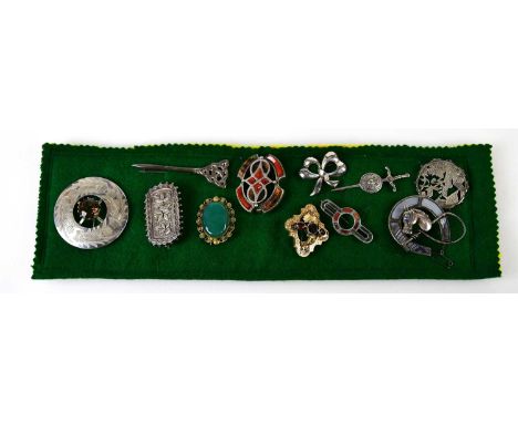 A group of brooches mounted on a felt pad, including a 19th century yellow metal garnet example with inscription to the rever