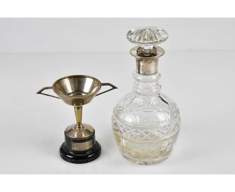 WILLIAM ADAMS LTD; a George VI hallmarked silver twin handled trophy cup on stand, Birmingham 1937, and a cut glass decanter 