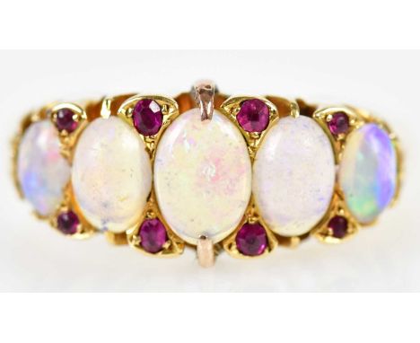 An Edwardian 18ct yellow gold opal and ruby ring set with five graduated oval opal cabochons and eight ruby chips, Birmingham