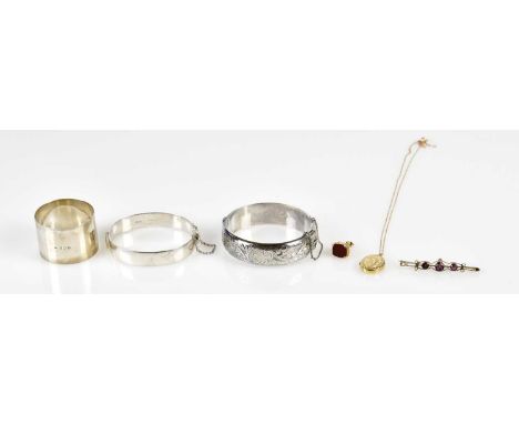 A 9ct yellow gold and blood stone seal charm, two hallmarked silver snap bangles, hallmarked silver and enamel napkin ring en