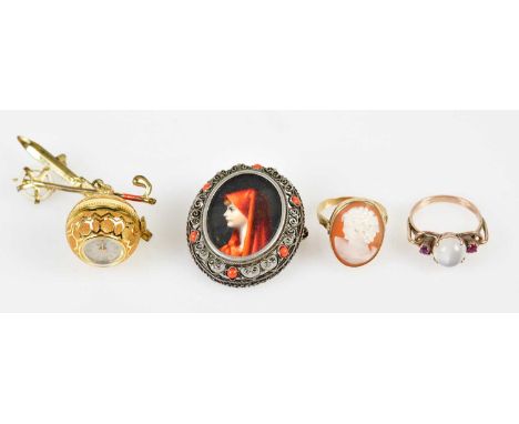 An 800 grade silver brooch with hand painted central panel depicting a maiden wearing a red overcoat, yellow metal cameo styl