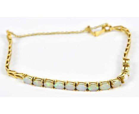 An 18ct yellow gold and opal set bracelet with twelve oval crystal Coober Pedy opals, each measuring 6 x 4mm, totalling appro