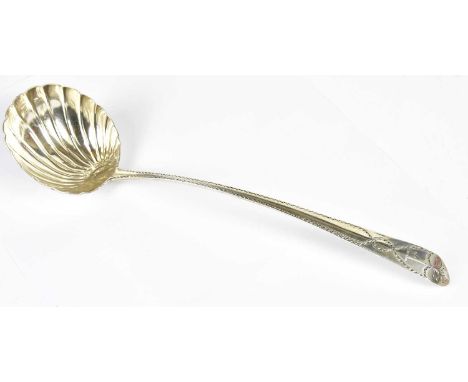 MICHAEL SMITH; a George III hallmarked silver soup ladle with shell shaped bowl and blind cut decoration to the handle, Dubli