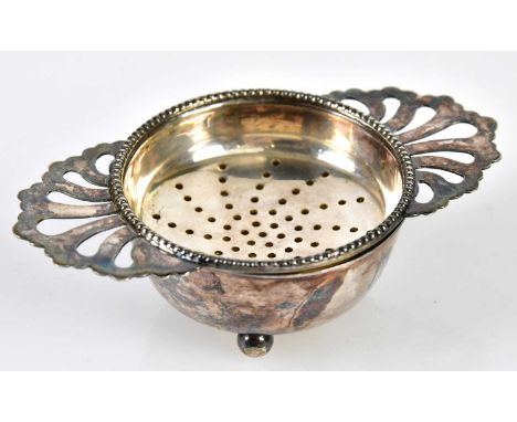 HAMPTON UTILITIES; an Elizabeth II hallmarked silver tea strainer and bowl, the cast beaded rim on three ball feet, Birmingha