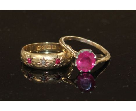 An early 20th century 18ct gold and gypsy set ruby and diamond three stone ring, size O, gross 1.9 grams and a yellow metal a