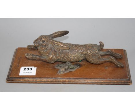 An Austrian cold painted door knocker modelled as a running hare, with oak mount, overall length 30cm, width 14cm, length of 