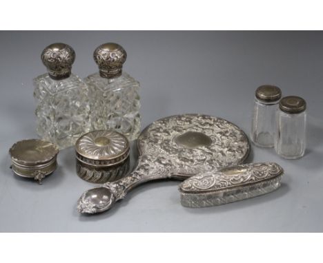 A late Victorian silver circular box and cover, a pair of similar silver mounted glass scent bottles, two mounted toilet jars