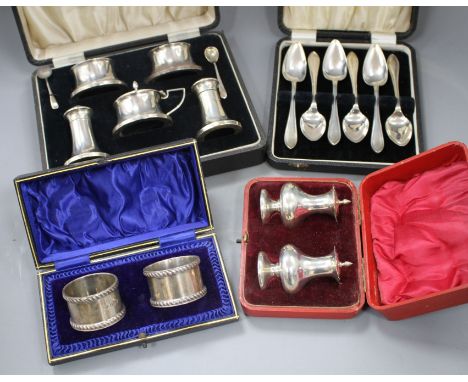 Four cased sets of silver, including pair of napkin rings, six grapefruit spoons, mounted condiment set and pair of pepperett