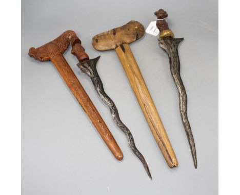 An Indonesian dagger kris, 19th century, wavy watered steel blade 35cms, carved wooden hilt and sheath; and another with 34cm