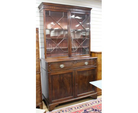A George III style mahogany bookcase, with two astragal glazed doors over a fall front drawer and panelled doors, W.127cm D.6