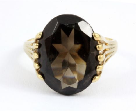 A 9ct yellow gold ring set with a large smokey quartz, quartz 1.5 x 1.3cm, (O.5).