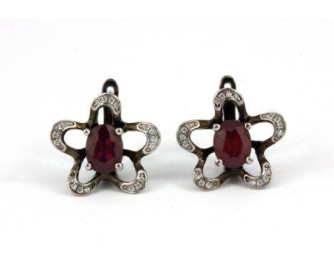 A pair of 925 silver oval cut ruby set flower shaped earrings, L. 1.5cm.
