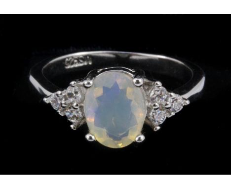 A 925 silver ring set with an oval cut opal and white stone set shoulders, (J.5).