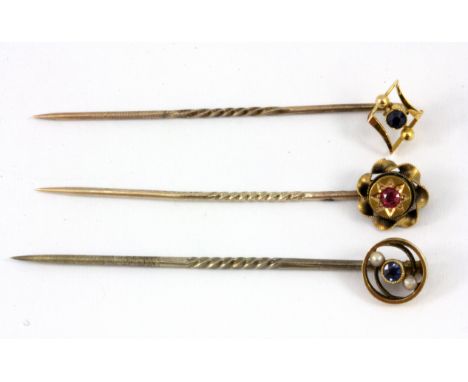 Two 15ct yellow gold stick pins and a further 9ct yellow gold stick pin.