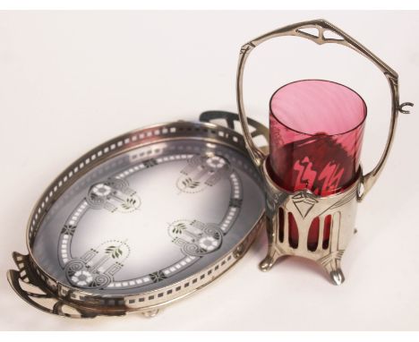 Two pieces of Art Nouveau style metal ware comprising a pierced silver plated preserve pot holder with cranberry glass insert