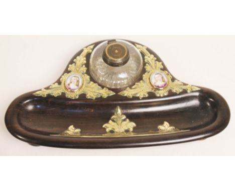 A Victorian brass mounted lignum vitae standish with glass inkwell and a pair of portrait miniature ovals, length 31cm.Condit