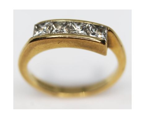 A hallmarked 18ct gold diamond ring featuring four channel set princess cut diamonds, gross wt. 3.6g, size K.  