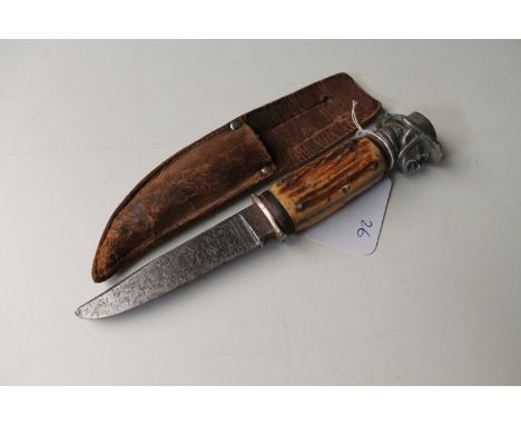 A novelty hunting knife with horn handle in leather sheath  CONDITION REPORT: 21cm overall. Blade pitted. Grip with some wobb