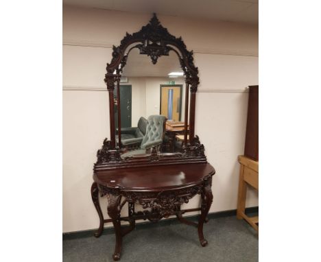 A heavily carved console table on cabriole legs with mirror back, width 137 cm