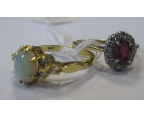 An 18ct opal and diamond ring, the oval opal cabochon set to either side with three small diamonds, London 1983, size J, toge