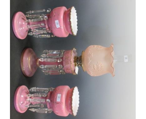 A pink glass and gilt decorated oil lamp (50cm high) together with a pair of pink glass and gilt decorated lustres (31cm high