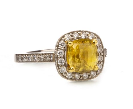 YELLOW SAPPHIRE AND DIAMOND RING, the cushion cut sapphire approximately 2.74 carats, within a round brilliant cut diamond ha