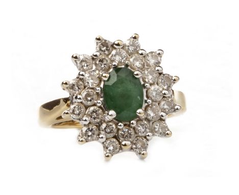 GREEN GEM AND DIAMOND CLUSTER RING, set with a central oval faceted green gem 7mm long and within a double diamond border wit