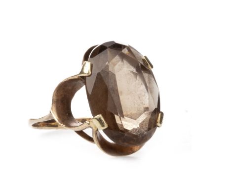 BROWN GEM SET RING, 1960s, the oval faceted gem 18mm long, within an openwork border, marked 375, size L 1/2, 4.7g
