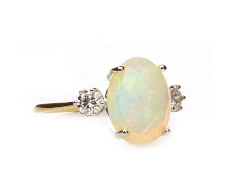 OPAL AND DIAMOND RING, set with an oval cabochon cut opal 10mm long flanked by two round brilliant cut diamonds, marked 750, 