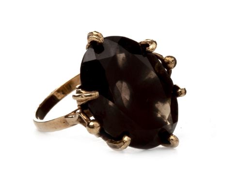 BROWN GEM SET RING, the oval brown gem 21mm long, with leaf motif claws, in nine carat gold, size N, 6.9g