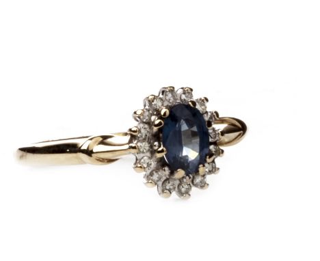 BLUE GEM AND DIAMOND CLUSTER RING, set with a central oval faceted blue gem 5.8mm long within a diamond halo, marked 375, siz