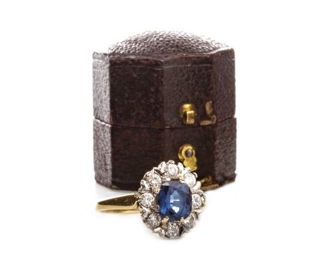BLUE GEM AND DIAMOND CLUSTER RING, set with a central oval faceted blue gem 7.3mm long, within a diamond halo set with round 