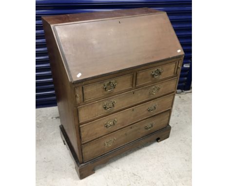 An early 20th Century mahogany bureau, the plain top over a sloping fall, enclosing a basic fitted interior with two drawers 