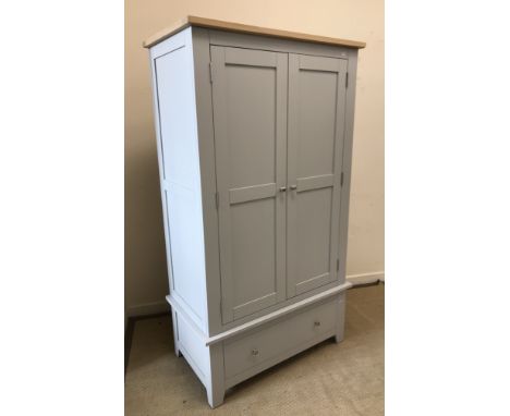 A modern grey painted wardrobe, the oak top over two panel doors enclosing a hanging space over a single drawer on bracket fe