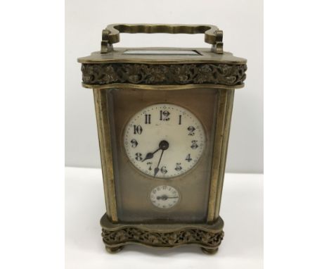 A late 19th Century French brass cased carriage clock, with serpentine banded relief work, grape and vine decoration, the cir