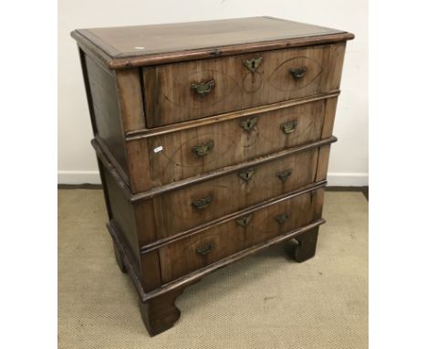 An early 18th Century walnut chest, the later top with applied moulded edge over four long drawers with brass swan neck handl