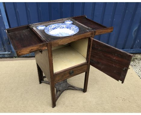 A 19th Century mahogany washstand, the double rising lid opening to reveal a fitted interior with rising mirror and Copeland 