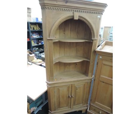 A pine corner display shelf with double cupboard under