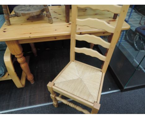 A traditional pine kitchen table and four ladder back chairs
