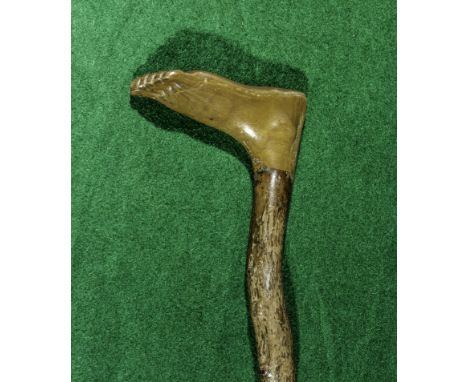 A walking stick with bone handle carved as a foot