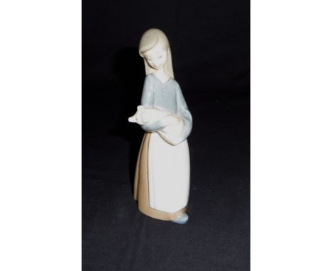 A small Lladro figure of a girl with a pig