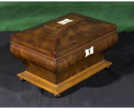 A mahogany tea caddy with ivory cartouche and escutcheon