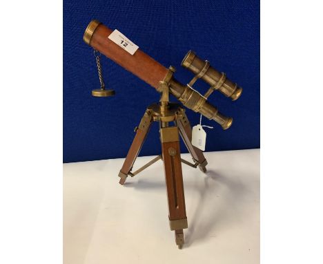 A BRASS AND LEATHER TELESCOPE ON A WOODEN STAND 