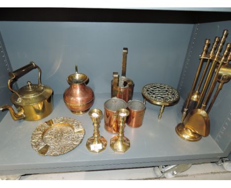 A selection of vintage brass and copper fire side items including graduated measuring cup set